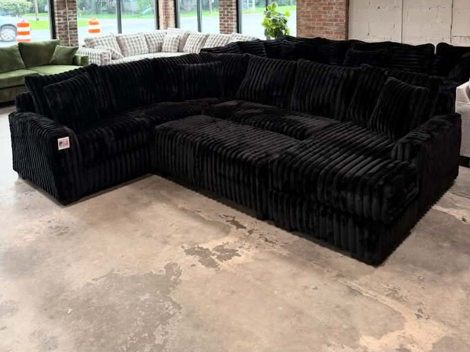 Black plush corduroy U-shaped sectional, showroom view 4