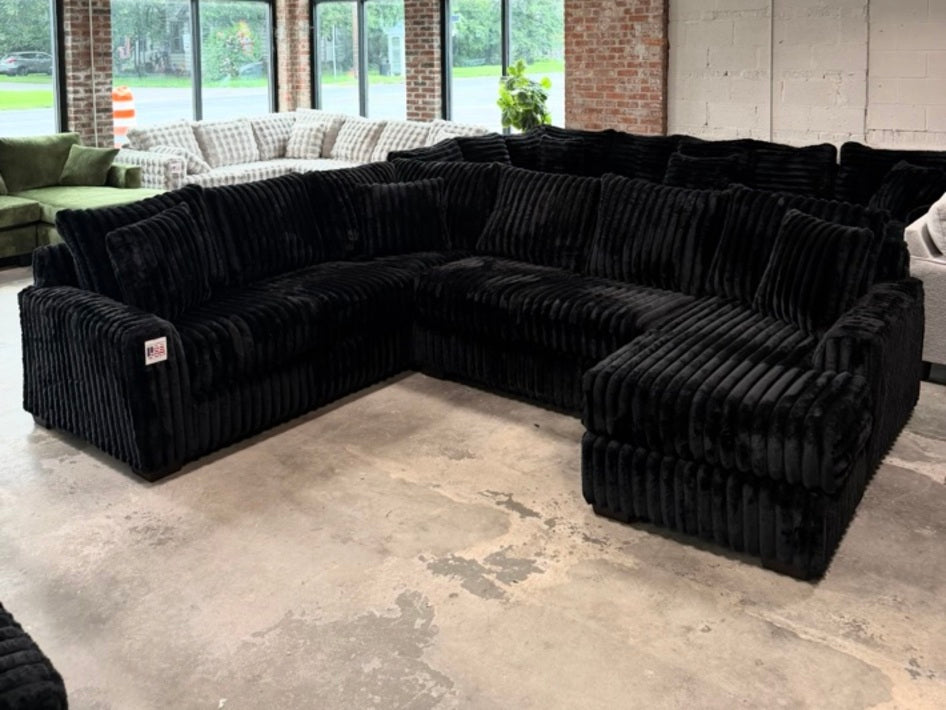 Black plush corduroy U-shaped sectional, showroom view 6