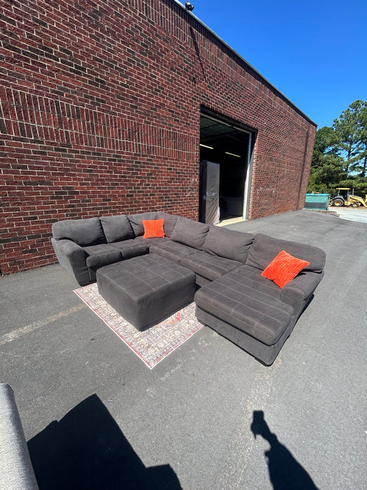 Used charcoal U-shaped sectional with chaise and matching ottoman shown